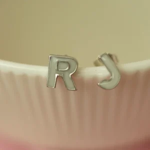 Pendientes con inicial elaborados con leche materna en plata de ley