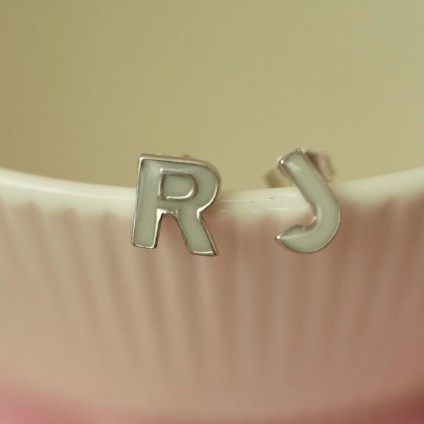 Pendientes con inicial elaborados con leche materna en plata de ley