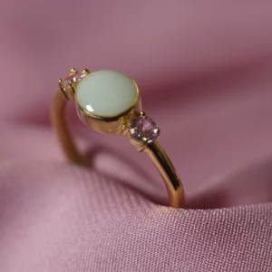 Anillo Aura de leche materna personalizado con piedra central y dos circonitas laterales.