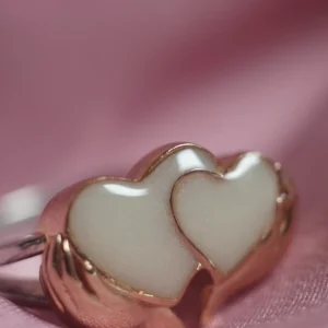 Anillo de leche materna con dos corazones sosteniddos por las manos