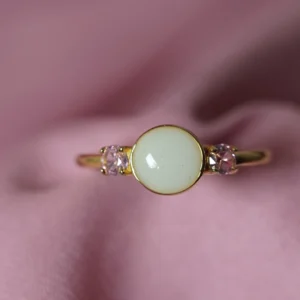 Anillo Aura de leche materna personalizado con piedra central y dos circonitas laterales.
