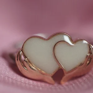 Anillo de leche materna con dos corazones sosteniddos por las manos