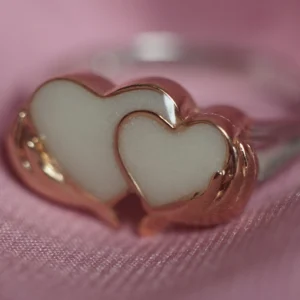 Anillo de leche materna con dos corazones sosteniddos por las manos