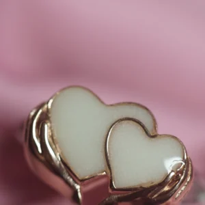 Anillo de leche materna con dos corazones sosteniddos por las manos