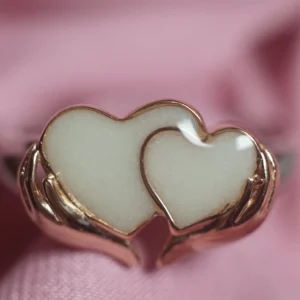Anillo de leche materna con dos corazones sosteniddos por las manos
