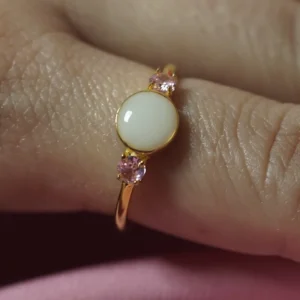 Anillo Aura de leche materna personalizado con piedra central y dos circonitas laterales.