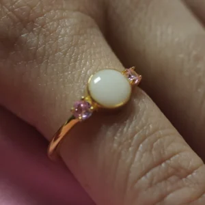 Anillo Aura de leche materna personalizado con piedra central y dos circonitas laterales.