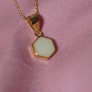 Primer plano del Colgante Uxia Mini, una joya de leche materna con diseño hexagonal minimalista.