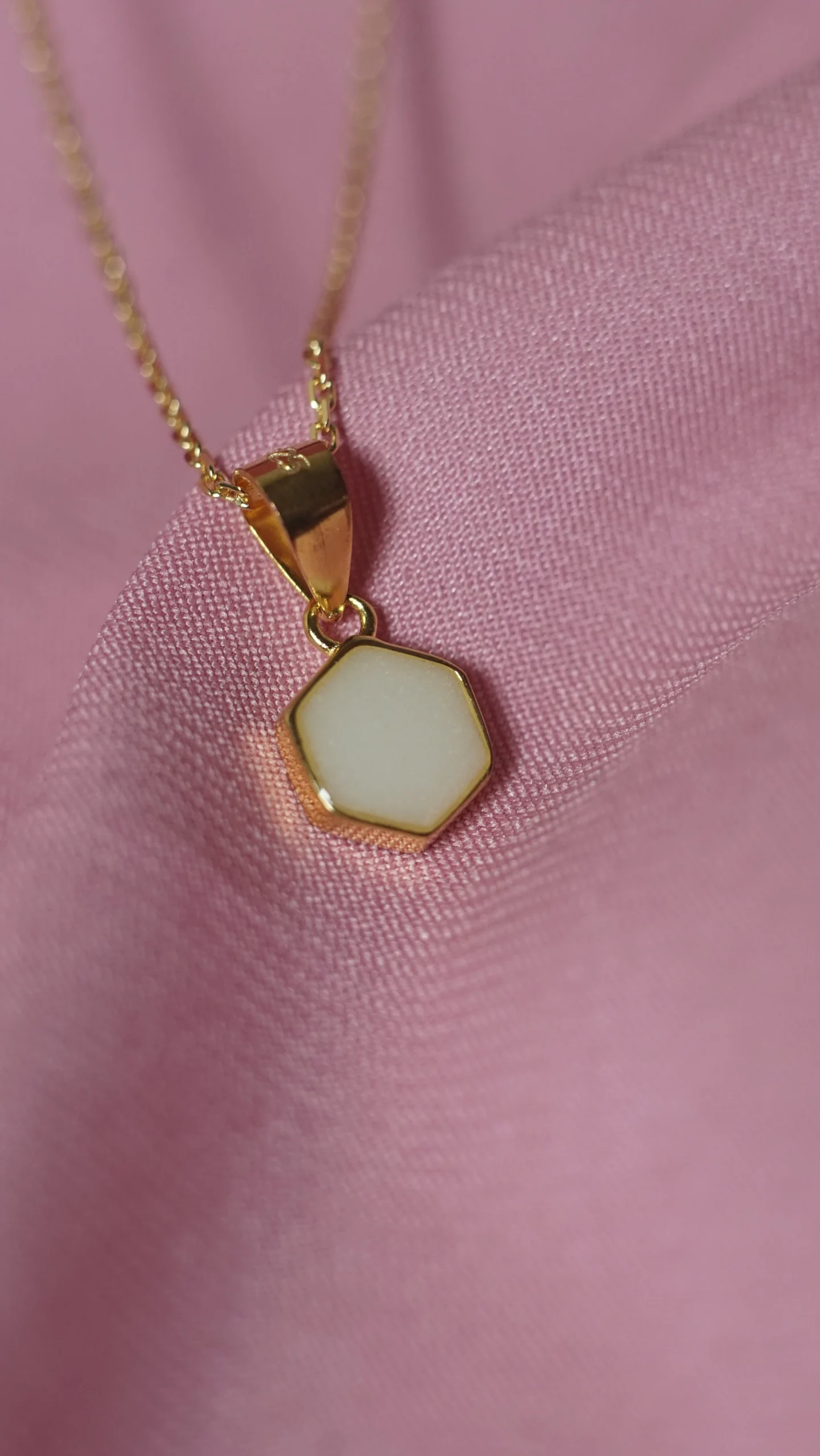 Primer plano del Colgante Uxia Mini, una joya de leche materna con diseño hexagonal minimalista.