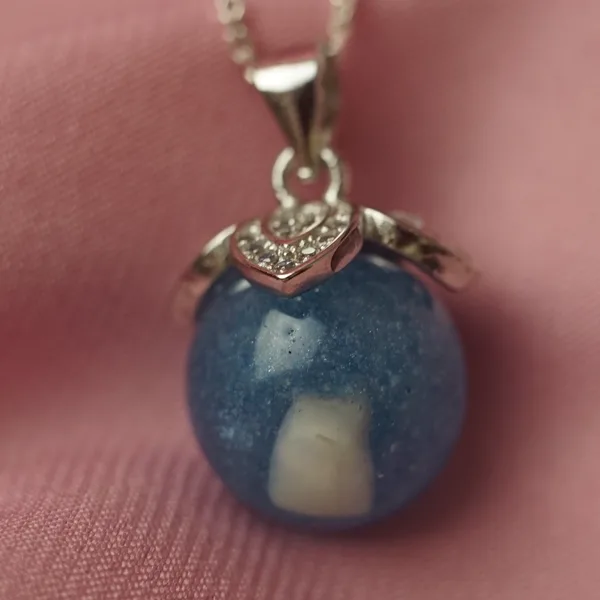 Colgante azul con un diente de leche dentro