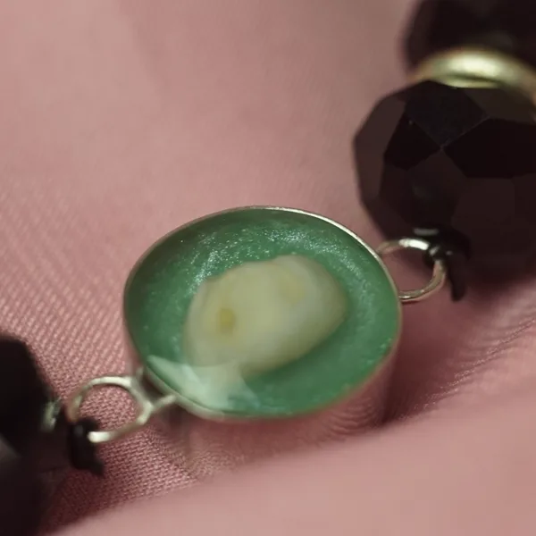 Pulsera con un diente de leche en resina verde