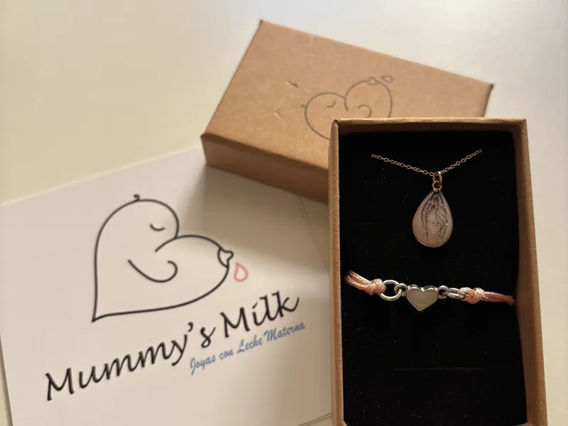 Foto de una clienta: colgante y pulsera de leche materna junto a la tarjeta de Mummy's Milk